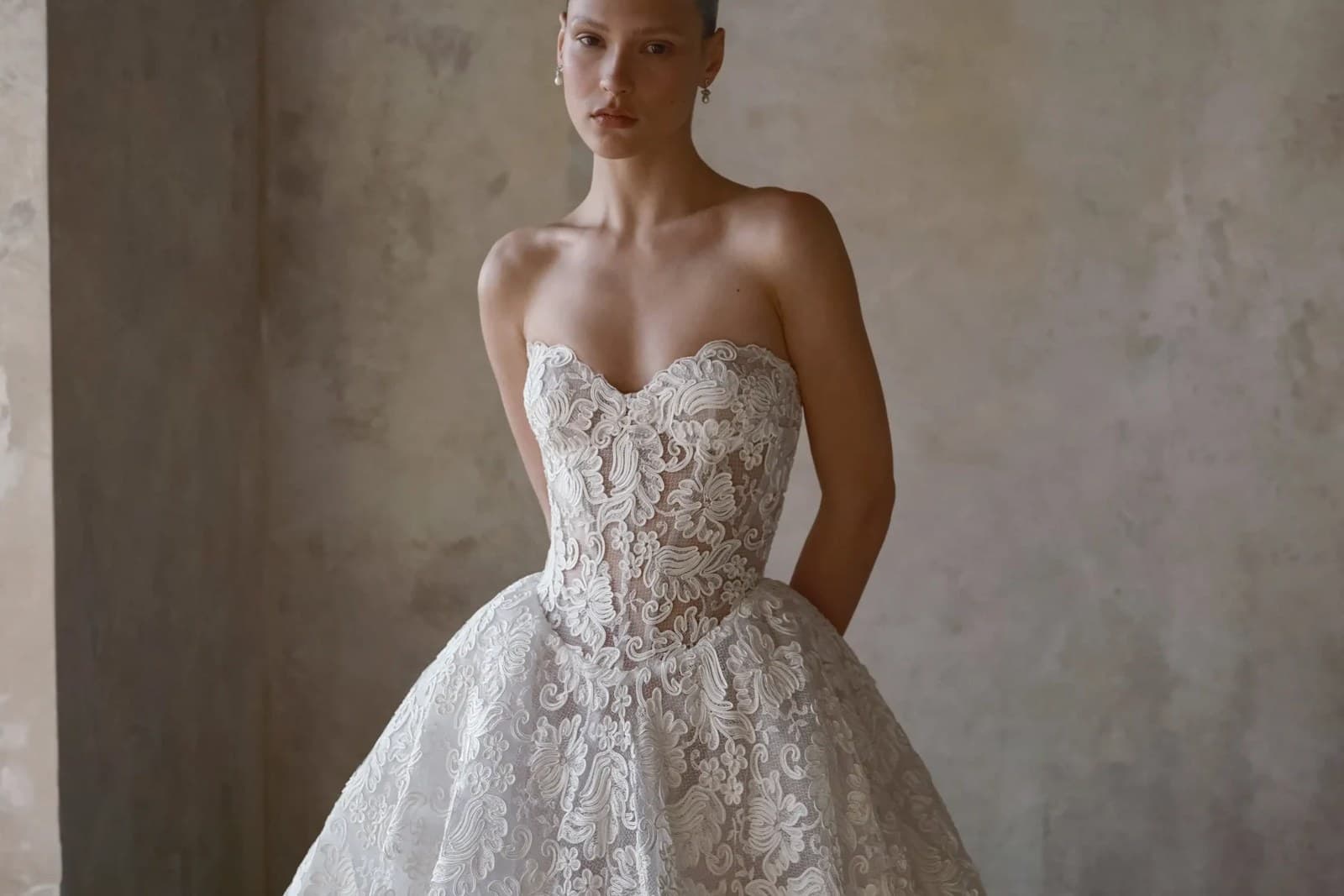 A lace corset bodice dipping to a point at the waist, above a full skirt